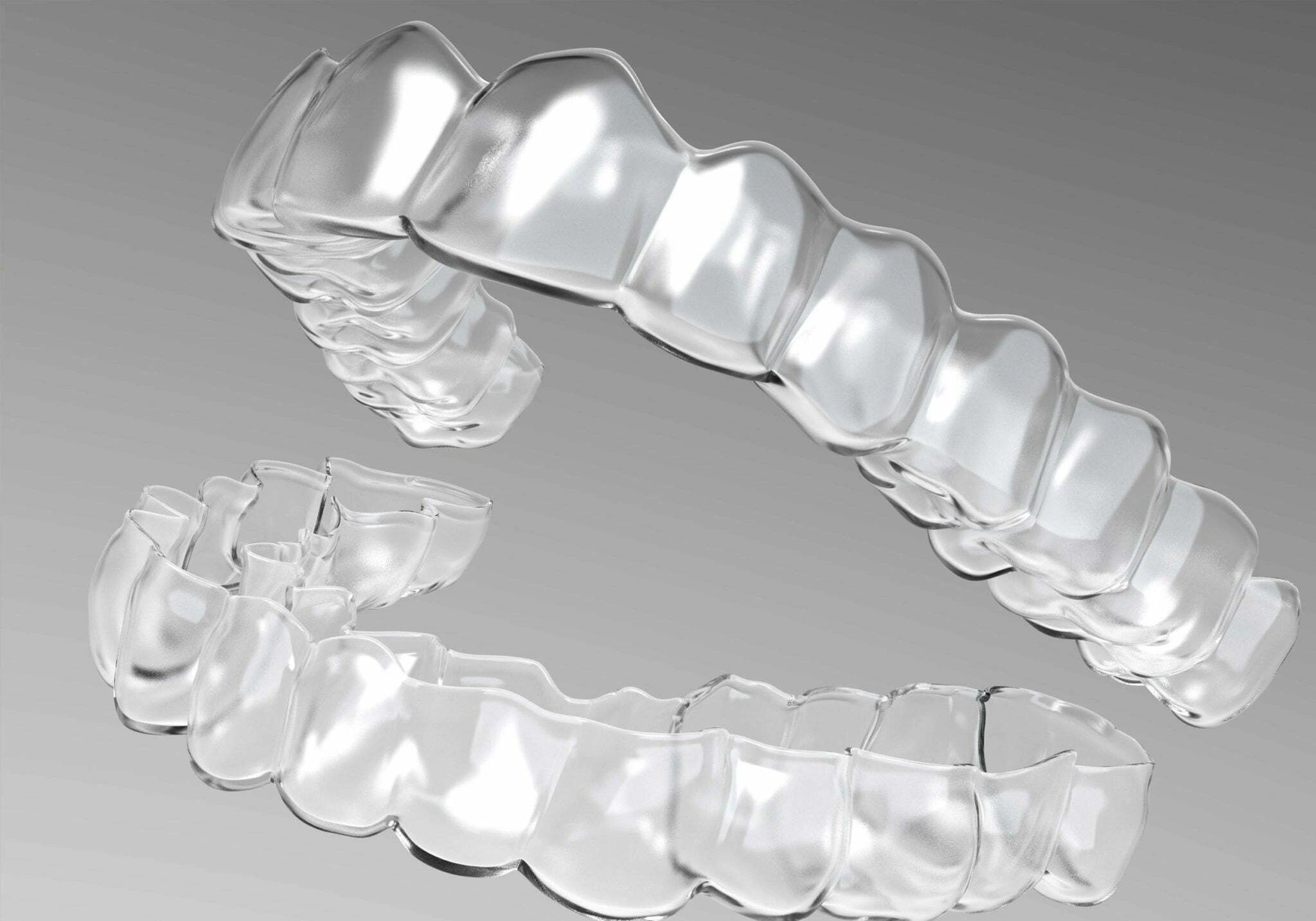 Clear dental aligners held for a closer look